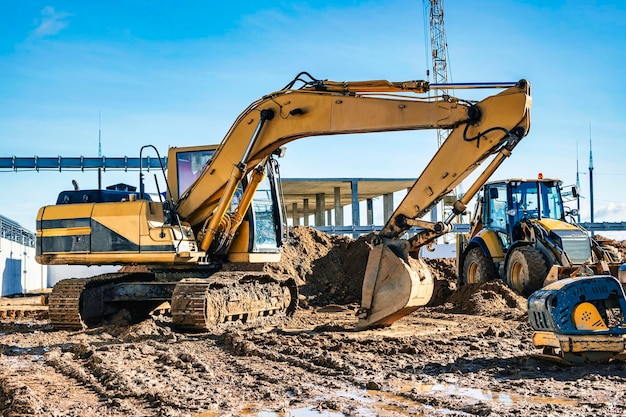 Gele rupsgraafmachine op de bouwplaats Grondwerken op een bouwplaats Modern grondverzetmaterieel