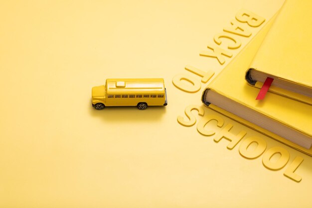Gele schoolbus met boeken en een inscriptie terug naar school concept foto