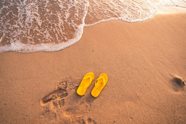 Gele teenslippers op het strand zomeravond