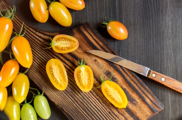 Foto gele tomaten op een houten bord.