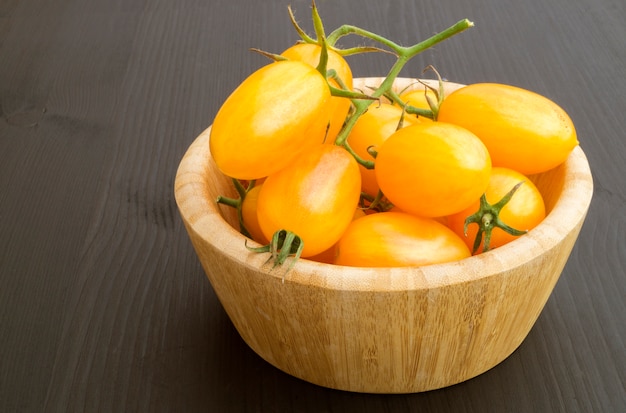 Gele tomaten op een houten bord.