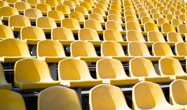 Gele tribunes zetels van tribune op sportstadion lege buitenarena concept van fans stoelen voor publiek culturele omgeving concept kleur en symmetrie lege stoelen modern stadion
