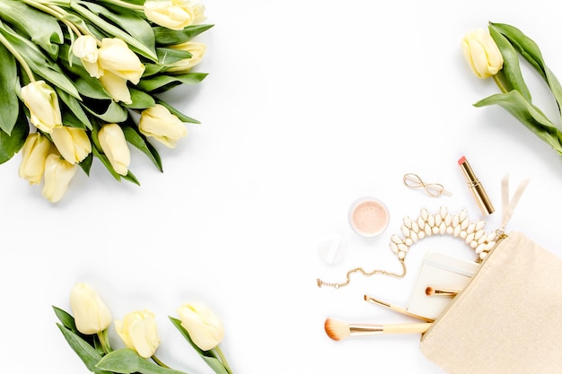 Gele tulp bloemen beige make-up tas make-up kwasten cosmetica gouden accessoires op witte backgro
