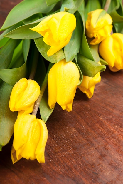Gele tulpen heldere Lentebloemen op houten achtergrond