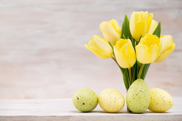 Gele tulpen, lentebloemen en paasdecoratie