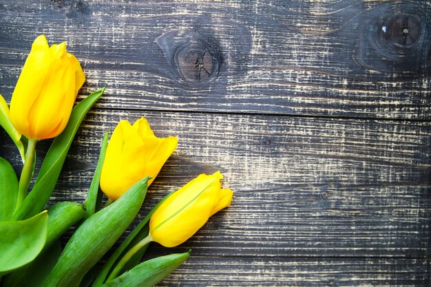 Gele tulpen liggen op oude vintage houten tafel