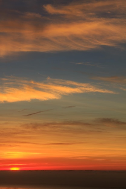 Gele warme zonsopgang met zeewolken en oceaan op de achtergrond Verticale foto