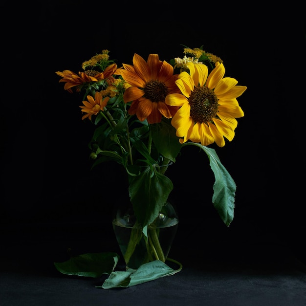 gele zonnebloemen in een vaas op een zwarte achtergrond