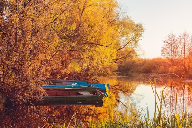 Gele zonsondergang in de herfst op de rivier met boten