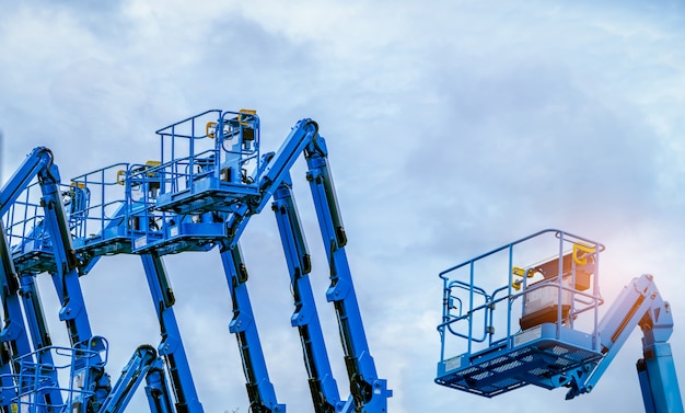 Gelede hoogwerker tegen blauwe hemel.