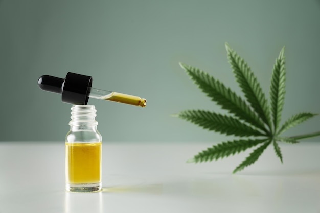 Gelegaliseerd cannabis sativa hennepblad en container met CBD-olie met druppeldeksel
