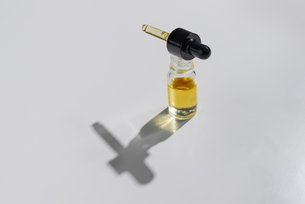 Gelegaliseerde CBD-olie in een doorzichtige glazen container met een geïsoleerde achtergrond met druppelaardeksel