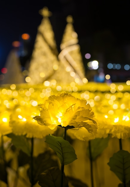 Geleide lichten van de gele bloem van de goudsbloemstof met gouden Kerstbomen bokeh