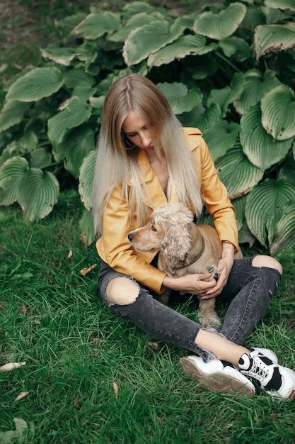 Geluid en vintage stijl. het jonge meisje met hond loopt in het park en geniet van de mooie de zomerdag