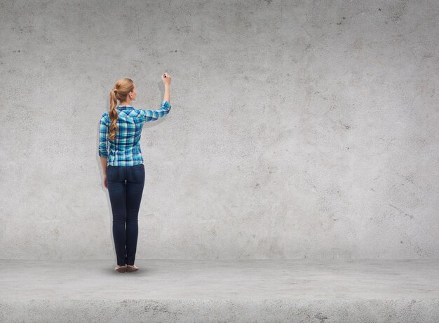 geluk en mensenconcept - glimlachende jonge vrouw die iets op virtueel scherm schrijft of tekent