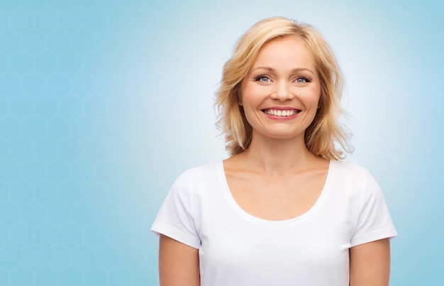 geluk en mensenconcept - glimlachende vrouw in leeg wit t-shirt over blauwe achtergrond