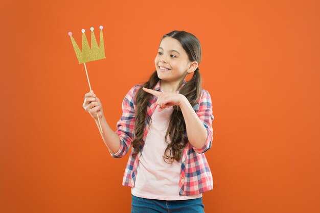 Geluk en vreugde concept Plezier en humor Meisjeskind met plezier Internationale kinderdag Superieure prinses Leuke dag om plezier te hebben met rekwisieten voor fotohokjes Speelse stemming Gouden kroon past bij haar