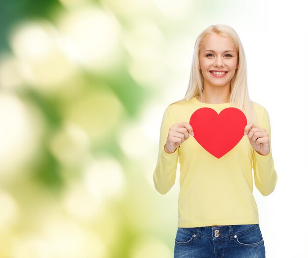 Foto geluk, gezondheid en liefde concept - lachende vrouw met rood hart