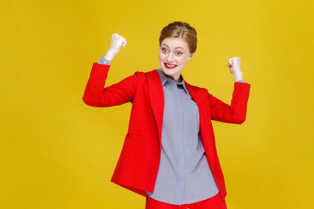 Geluk optimistische roodharige zakenvrouw in rood pak win