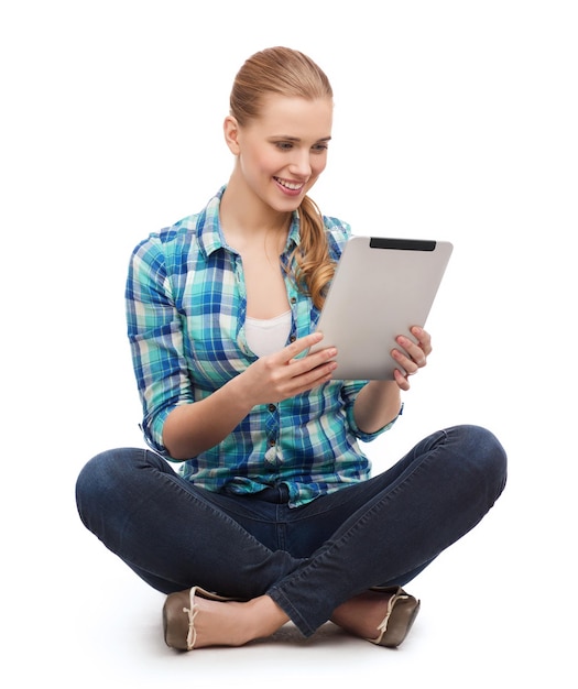 geluk, technologie, internet en mensen concept - glimlachende jonge vrouw in vrijetijdskleding sitiing op de vloer met tablet pc-computer