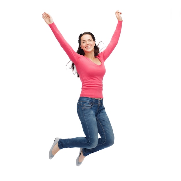 geluk, vrijheid, beweging en mensenconcept - glimlachende jonge vrouw die in lucht springt