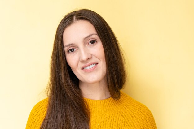 Gelukkig aantrekkelijke Tataarse jonge vrouw glimlachend en lachen geïsoleerd op gele achtergrond met kopie ruimte gezicht portret