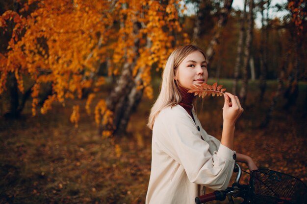 Gelukkig actieve jonge vrouw fietsten in herfst park.