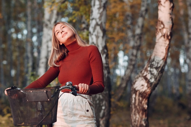 Gelukkig actieve jonge vrouw fietsten in herfst park