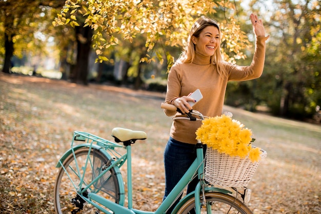 Gelukkig actieve vrouw fietsten in herfst park