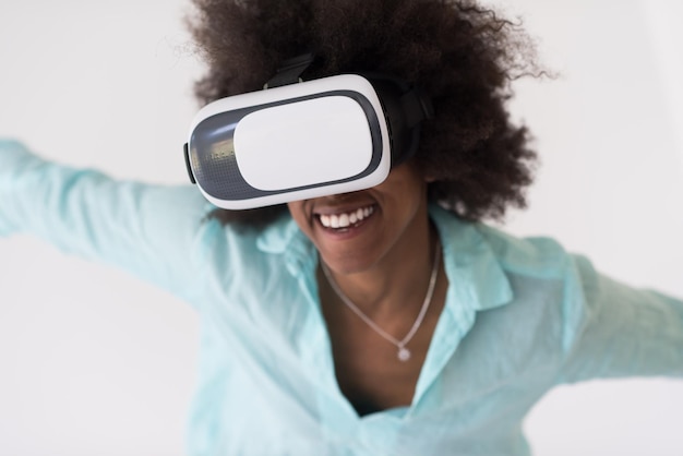 Gelukkig Afrikaans Amerikaans meisje dat ervaring opdoet met het gebruik van een VR-headsetbril van virtual reality, geïsoleerd op een witte achtergrond