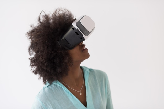 Gelukkig Afrikaans Amerikaans meisje dat ervaring opdoet met het gebruik van een VR-headsetbril van virtual reality, geïsoleerd op een witte achtergrond