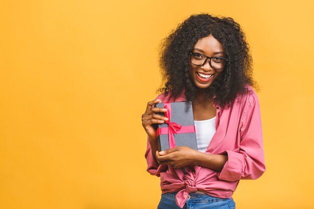 Gelukkig Afro-Amerikaanse dame in casual opzij kijken en lachen terwijl u aanwezig houdt