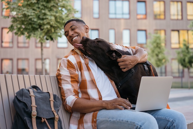 Gelukkig Afro-Amerikaanse man knuffelen met schattige hond beste vrienden concept