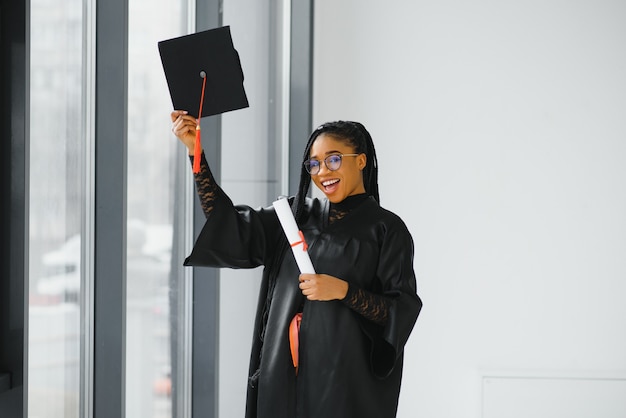 Gelukkig Afro-Amerikaanse vrouwelijke student met diploma bij afstuderen