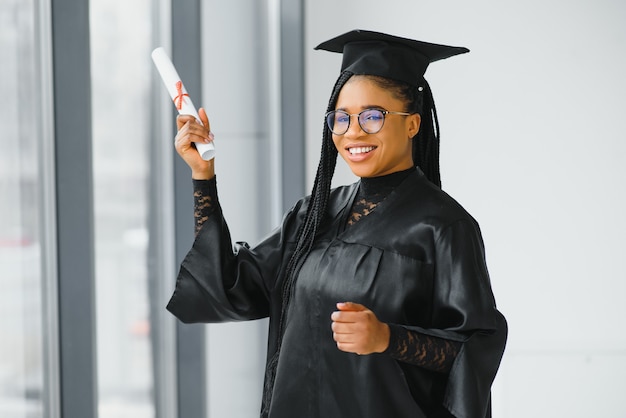 Gelukkig Afro-Amerikaanse vrouwelijke student met diploma bij afstuderen