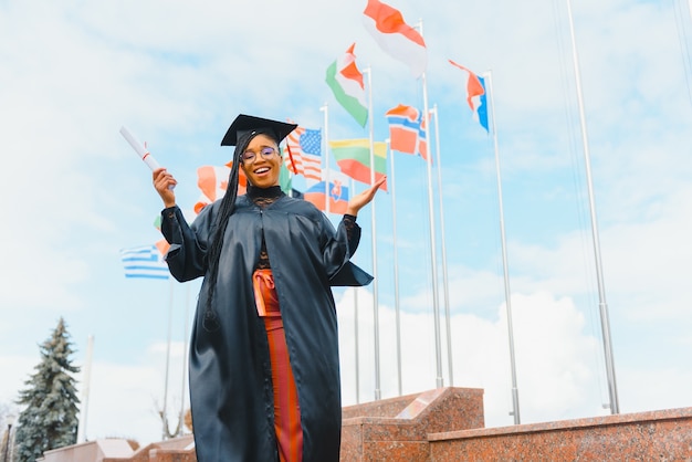 Gelukkig Afro-Amerikaanse vrouwelijke student met diploma bij afstuderen