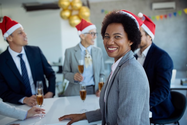 Gelukkig Afro-Amerikaanse zakenvrouw genieten op kerstfeest op kantoor