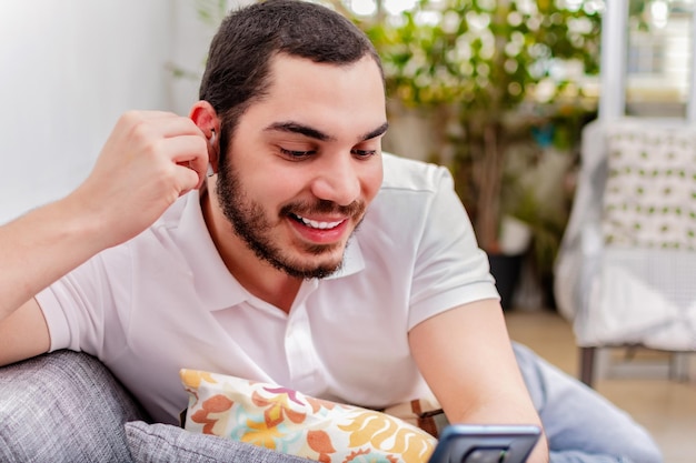 Gelukkig arabische man met behulp van mobiele telefoon met draadloze koptelefoon