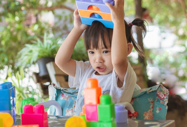 Gelukkig Aziatisch kindmeisje dat het plastic blokspeelgoed speelt Leren en onderwijs