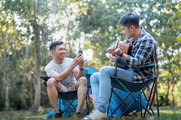 Gelukkig Aziatisch mannelijk homoseksueel koppel op camping samen in een bos romantische roeping reis lgbt concept