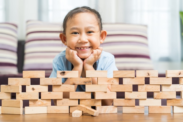 Gelukkig Aziatisch meisje speelt thuis houten speelgoed