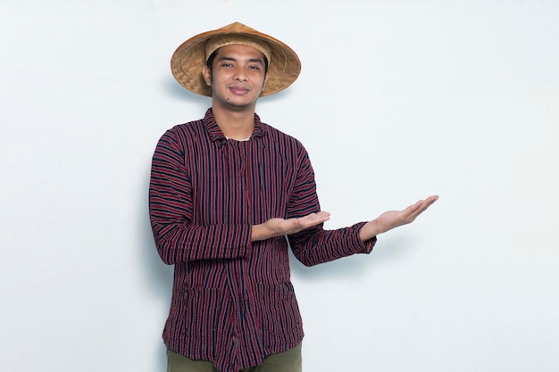 Gelukkig aziatische boer wijzend met de vingers naar verschillende richtingen geïsoleerd op een witte achtergrond