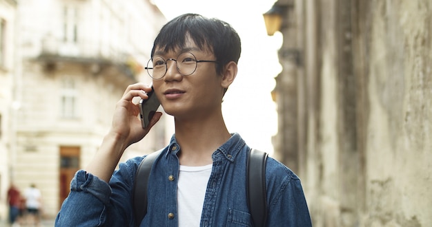 Gelukkig Aziatische man praten aan de telefoon