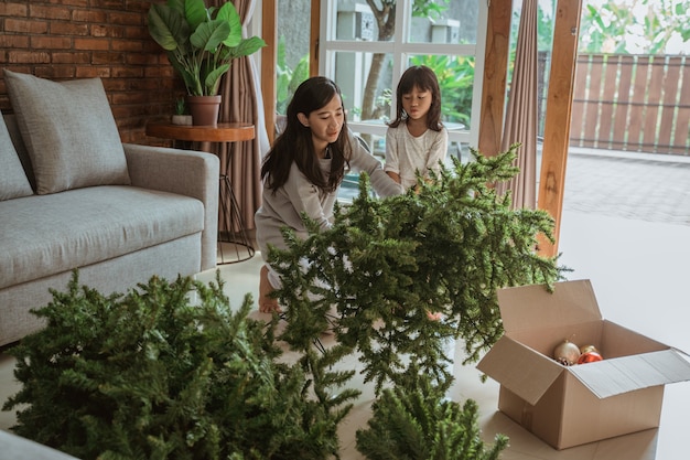 Gelukkig Aziatische moeder en dochter die de kerstboom versieren