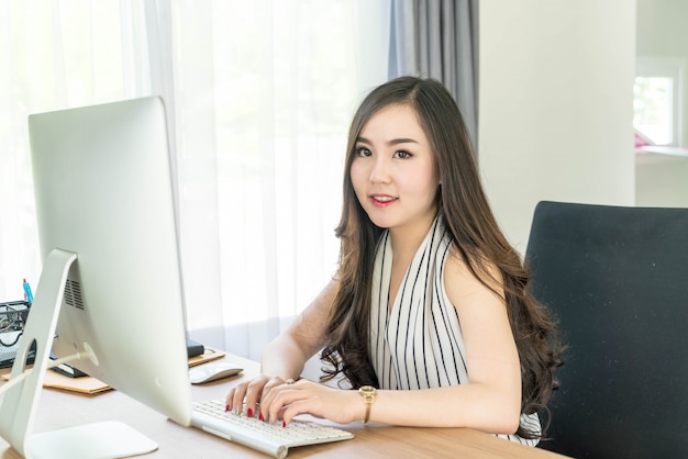 gelukkig Aziatische vrouw in office