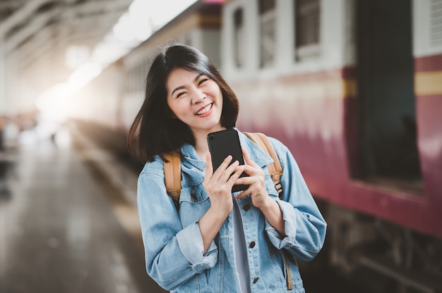 Gelukkig Aziatische vrouw op treinstation