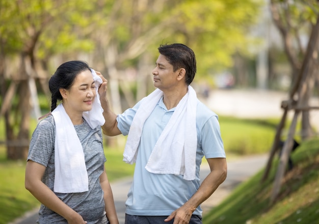 Gelukkig Azië senior paar joggen buiten in park.