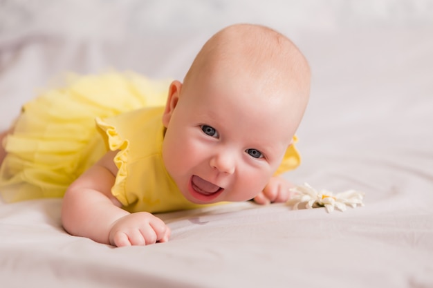 Gelukkig babymeisje dat op bed ligt