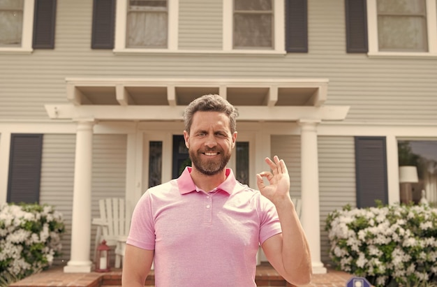 Foto gelukkig bebaarde man makelaar in de buurt van nieuw huis na huur of koop nieuwe hypotheek