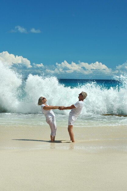 Gelukkig bejaarde echtpaar dansen op tropisch strand